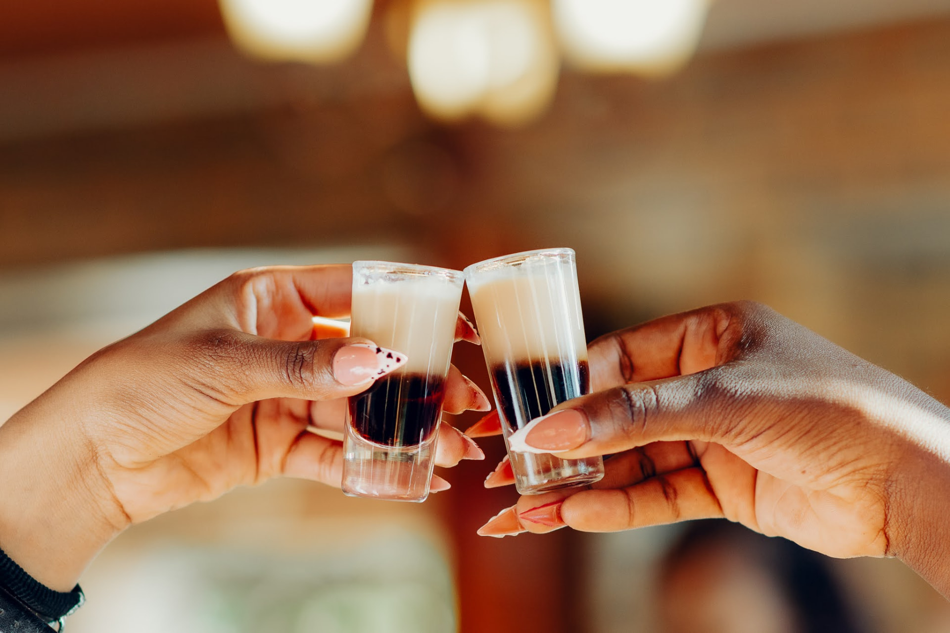 Two layered shots raised in a toast at the Kiwi Cafe bar