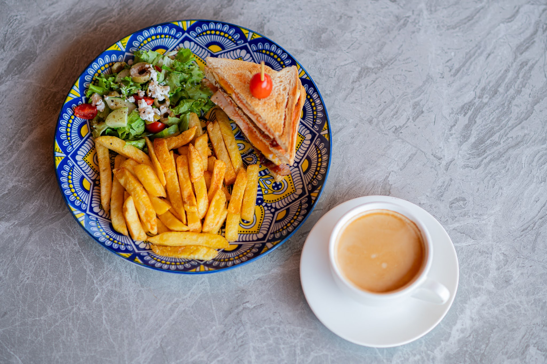 Toasted club sandwich with chips, salad and a cup of coffee