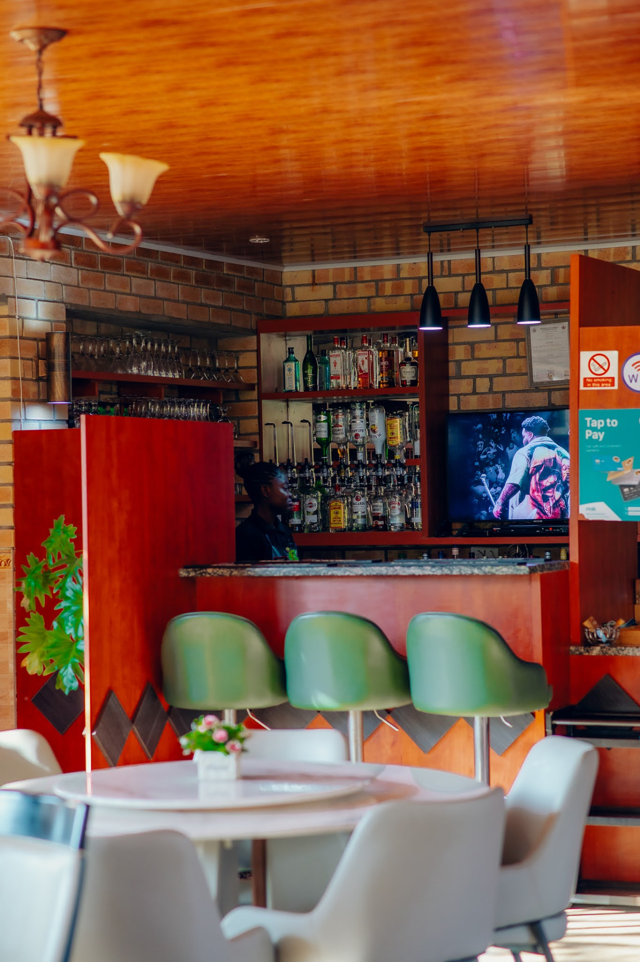 The Kiwi Cafe bar with green stools, pendant lights and a stocked shelf